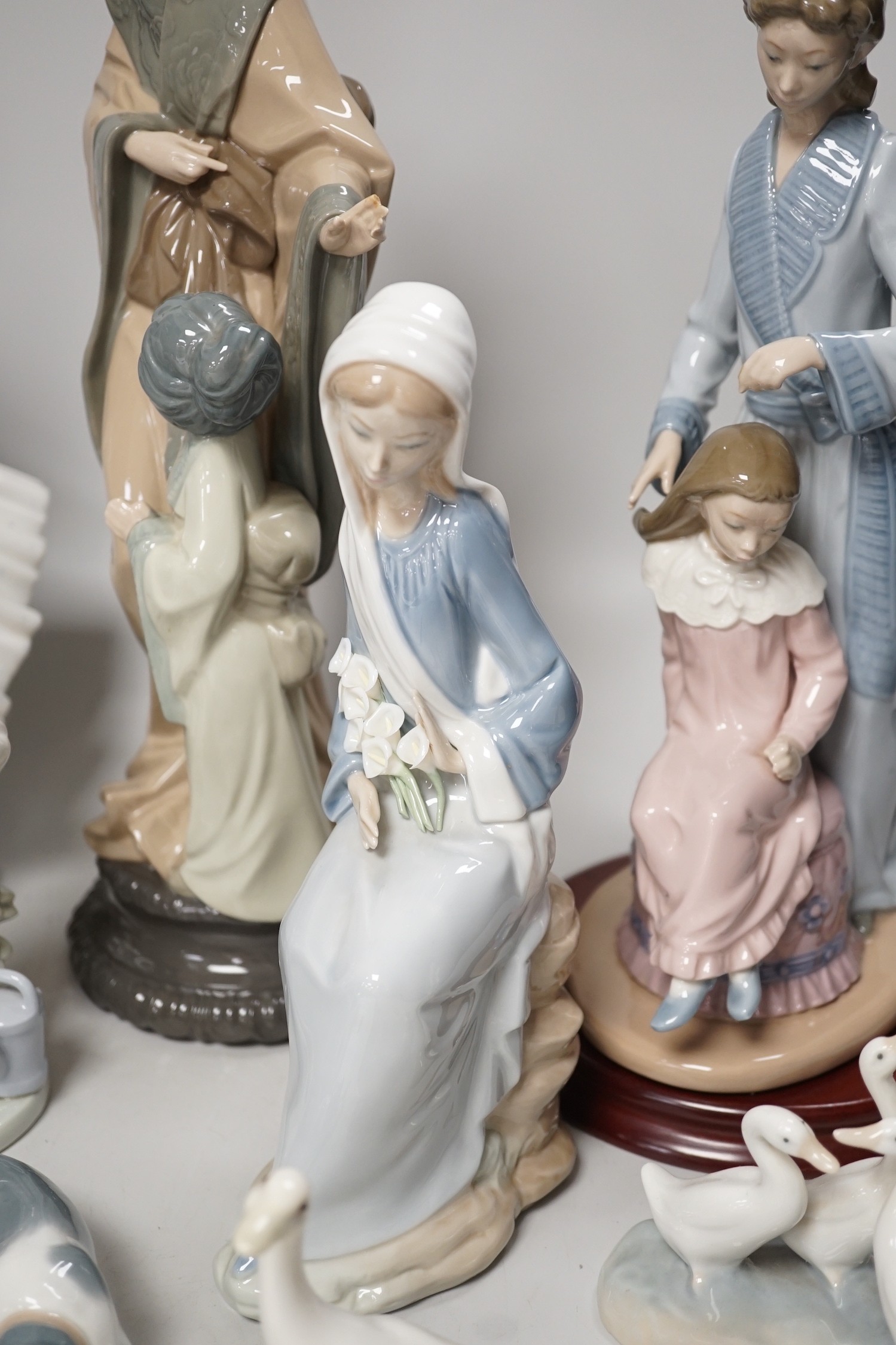 Seven Lladro and two Nao porcelain figures together with another, stuck to base so mark can’t be seen. Tallest 38cm